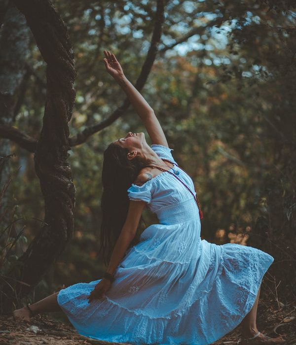 Woman in a graceful tree yoga pose in a bright, airy room.